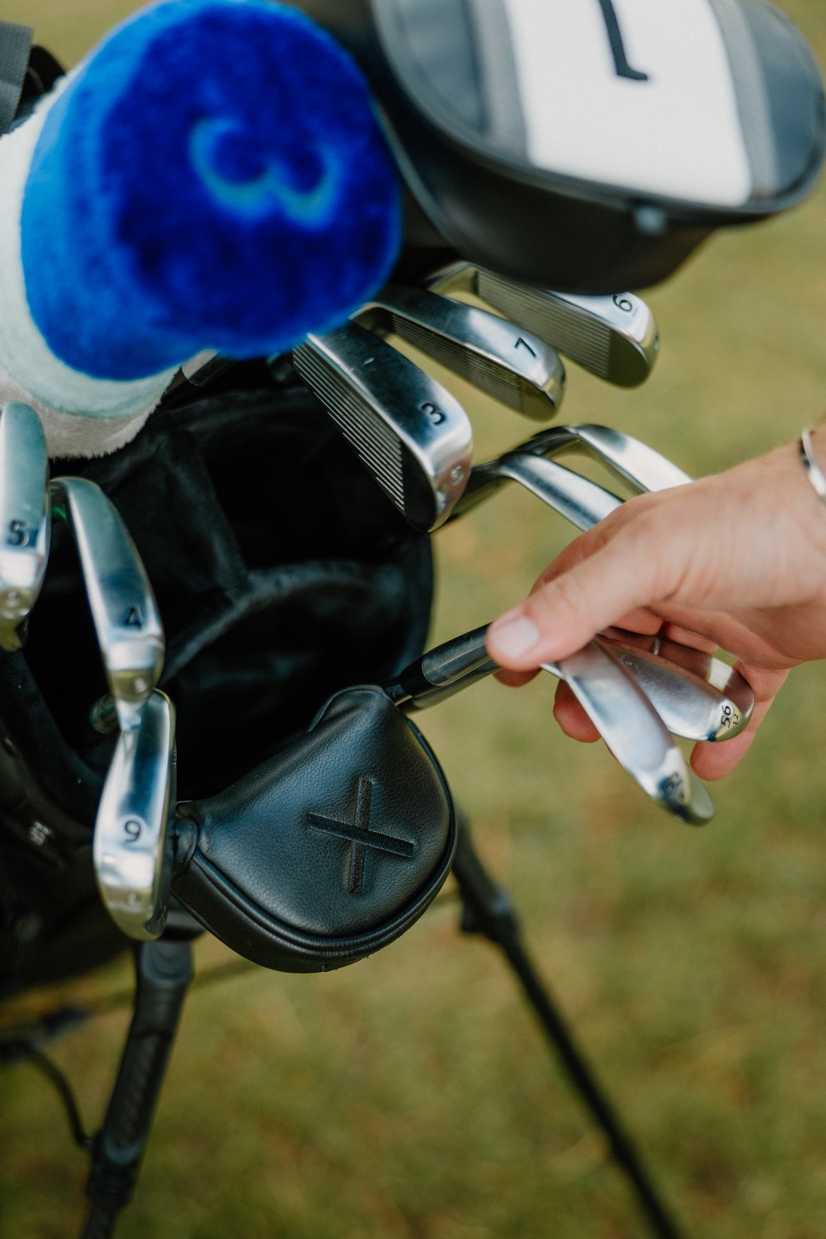 A Caley iron being pulled from a golf bag on the course