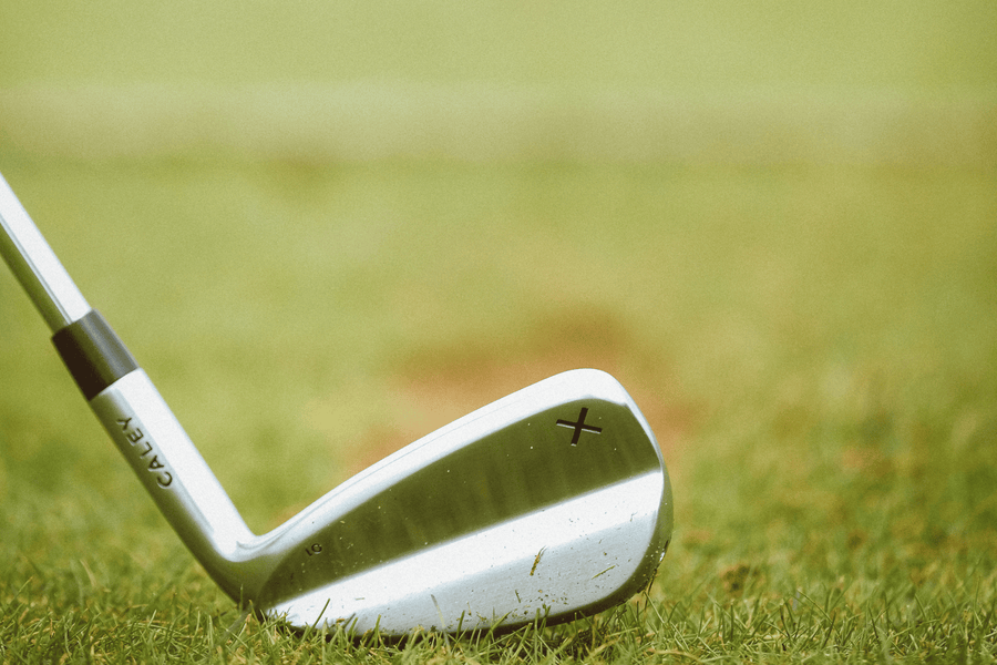 A Caley 01 iron at address on the fairway